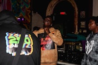 a man in a hoodie standing next to a group of people