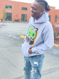 a young man wearing ripped jeans and a hoodie